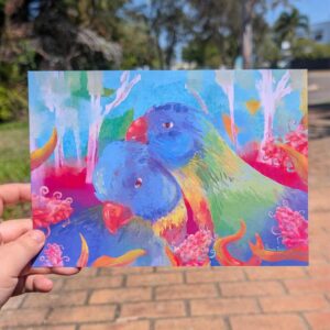 Rainbow Lorikeats cudiling infrunt a dreamy aus bush scape. Grivilia flowers and gum leaves frame the birds in frount.